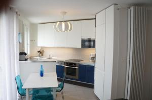 a kitchen with blue cabinets and a white table at T1 Moderne Plage des Catalans in Marseille
