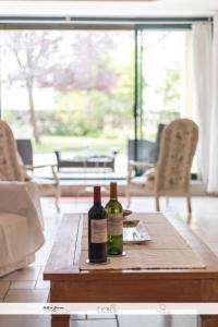two bottles of wine sitting on top of a wooden table at LA GRANGE DE BELLEFONTAINE et sa piscine privée in Bellefond