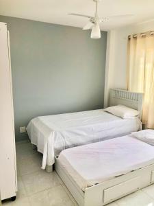 サン・ペドロ・ダ・アルデイアにあるCobertura São Pedro da Aldeiaのベッドルーム1室(ベッド2台、シーリングファン付)