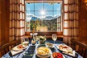 a table with food and wine glasses and a window at Locanda Montana in San Vito di Cadore