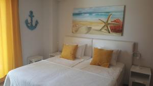a bedroom with a white bed with yellow pillows at Sotavento Las Terrazas II, La Tejita in La Tejita +28 photos