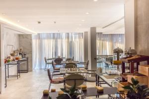 ジッダにあるEwaa Express Hotel - Al Rawdaのテーブルと椅子と窓のあるレストラン +31枚の写真