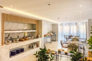 a large kitchen with tables and chairs in a room at Ewaa Express Hotel - Al Rawda in Jeddah