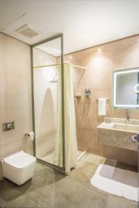a bathroom with a shower and a toilet and a sink at Ewaa Express Hotel - Al Rawda in Jeddah