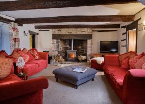 a living room with red couches and a fireplace at Deer's Leap Retreat in West Anstey