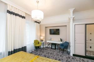 a hotel room with a bed and a desk at Orfei GOLD in Saint Petersburg