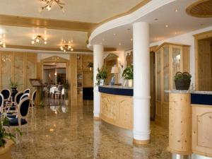 a lobby with columns and a bar in a building at Hotel Laguna in San Zeno di Montagna