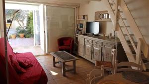 ein Wohnzimmer mit einem TV und einer Treppe in der Unterkunft Proche commerces et plage charmant pavillon très bien équipé - AYG10 in Saint Cyprien Plage