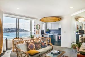 sala de estar con sofá y mesa en Bondi Cloud Surf House by Sydney Dreams, en Sídney