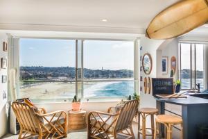 una stanza con tavolo e sedie e una grande finestra di Bondi Cloud Surf House by Sydney Dreams a Sydney