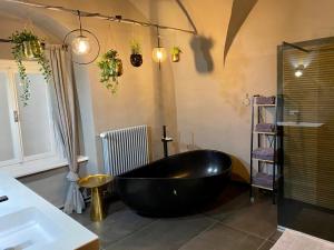 a bathroom with a black tub and a sink at Die Burg 23 in Klagenfurt