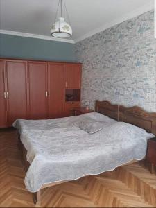 hotel في Chiatʼura: غرفة نوم بسرير كبير وجدار من الطوب