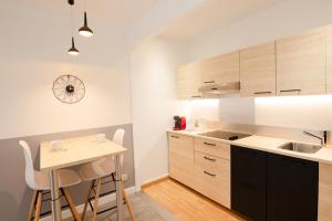 a kitchen with wooden cabinets and a small table at Roudadoux in Issoire