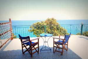 a table and two chairs on a balcony with the ocean at To Limanaki in Chorefto