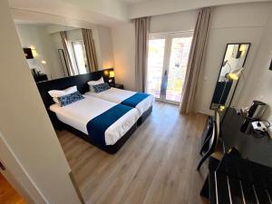 a hotel room with a bed and a large window at Lisbon City Hotel by City Hotels in Lisbon