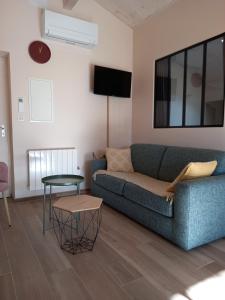 a living room with a blue couch and a table at Gîte Mamie Cocotte in Fuissé