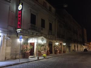 un edificio con un cartello sul lato di esso di notte di Hotel Archimede Ortigia a Siracusa