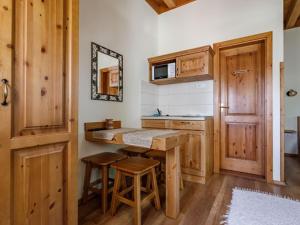 a kitchen with wooden cabinets and a counter with stools at Tóth Vendégház és Apartmanház Újfehértó in Újfehértó