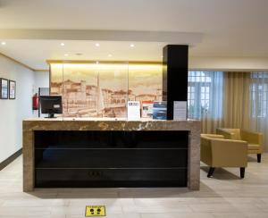 a lobby with a large fireplace in a building at Veneza Hotel in Aveiro