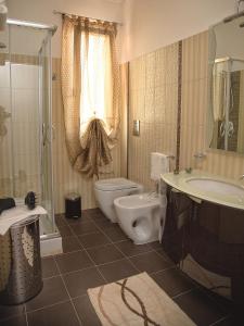 a bathroom with a toilet and a sink and a shower at La Conchiglia Case Vacanze in Balestrate