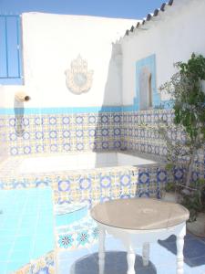 uma mesa num quarto com azulejos azuis e brancos em Dar Warda em Bizerte