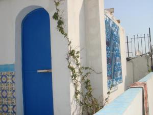 a blue door on the side of a white building at Dar Warda in Bizerte