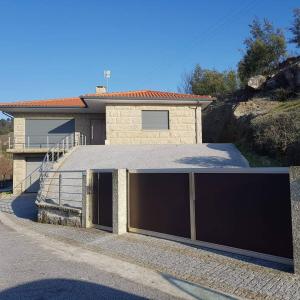 ein Haus mit zwei Garagentüren davor in der Unterkunft Casa da Batoca - Rossas in Vieira do Minho