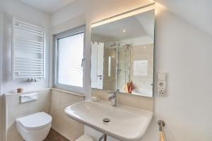 a bathroom with a sink and a toilet and a mirror at Ferienwohnung Neukölln in Berlin