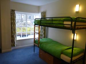 a room with two bunk beds and a window at Ingleton Hostel in Ingleton