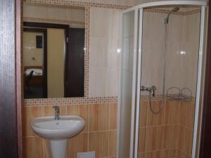 a bathroom with a sink and a shower with a mirror at Parkhotel Terezín in Terezín
