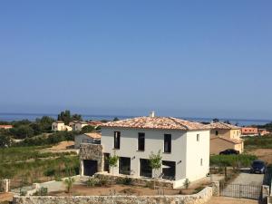 uma casa branca no meio de um campo em Villa grand confort à 500m de la plage de LOZARI em Palasca