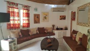 uma sala de estar com um sofá e uma mesa em Résidence Safari Village em Saly Portudal