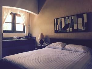 um quarto com uma cama branca e uma janela em Posada del Cortes em Loreto
