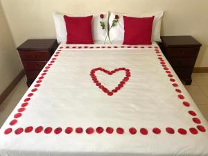 ein Bett mit einem darauf bemalten Herz in der Unterkunft The Intimate Paradise Close to 876 Beach in Falmouth