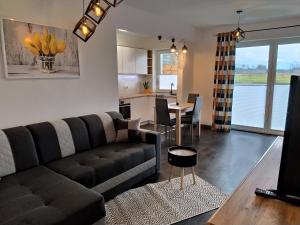 a living room with a couch and a table at Apartament 36 in Nowy Targ