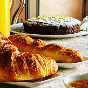 een tafel met twee borden brood en een taart bij B&B Mugnos Charme Living in Licodia Eubea