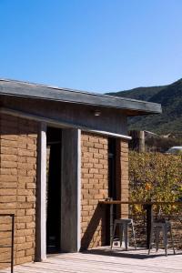 a brick building with two tables and two chairs at UvaUva eco-retreat in Valle de Guadalupe