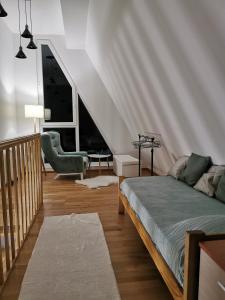 ein Wohnzimmer mit einem Bett und einer Treppe in der Unterkunft Apartman Divcigora Sokic in Divčibare