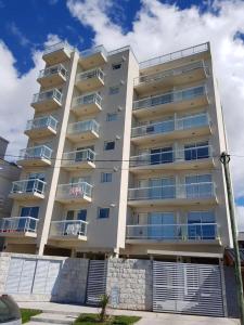 ein hohes weißes Gebäude mit Balkonen darauf in der Unterkunft DEPTOS VIP en EDIFICIO FRENTE AL MAR-ZONA CONSTITUCION in Mar del Plata