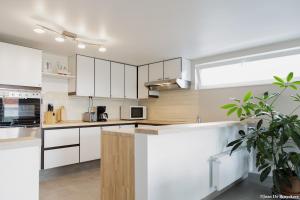 a kitchen with white cabinets and a large window at Vakantiewoning Zonnehof in Sint-Margriete