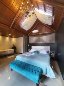 a bedroom with a large bed with a blue bench at Eco Hotel Bouganville in São José dos Pinhais