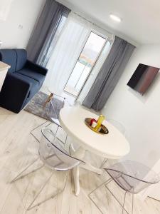 a living room with a white table and chairs at APARTAMENT PRZY WYDMIE in Grzybowo