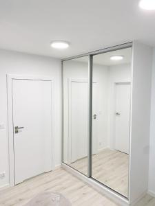 a room with sliding glass doors and wood floors at APARTAMENT PRZY WYDMIE in Grzybowo