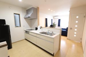 a white kitchen with a sink and a refrigerator at 5 minutes Shin-Osaka 3 in Osaka