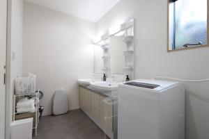 a white bathroom with a sink and a washing machine at 5 minutes Shin-Osaka 3 in Osaka +40 photos