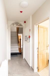 a hallway with a door and a stairway at Vakantiewoning Zonnehof in Sint-Margriete