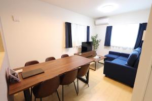 a room with a table and chairs and a blue couch at 5 minutes Shin-Osaka 3 in Osaka