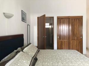 a bedroom with a bed and a wooden door at Hotel San Joaquin SA de CV in Colima