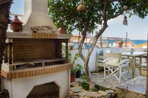 a patio with an outdoor oven with a table and chairs at Avra Apartments in Kalyves