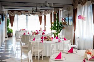 a banquet hall with white tables and pink napkins at Pensiunea Luminita in Târgu Jiu +48 photos